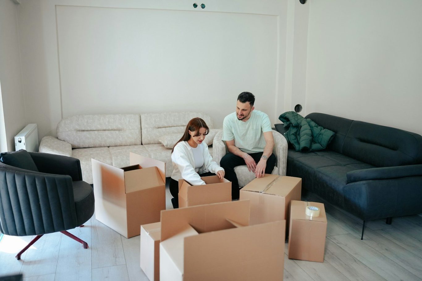 Couple unpacking cardboard boxes during a home move with Lewis & Co Moving Group.